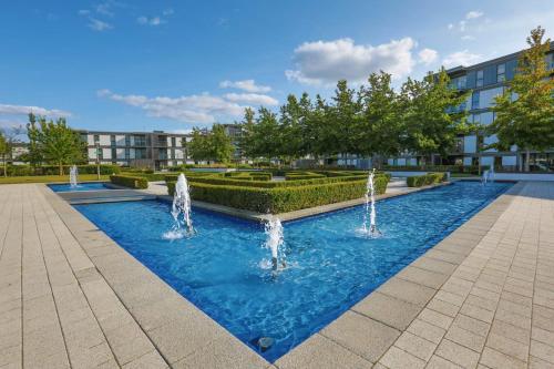 a pool with water fountains in a building at iSTAY APARTMENTS at VIZION - Fully Equipped Modern Serviced Apartments with Balconies, Superfast Broadband, Free Allocated Parking Space, 24h Security, Rooftop Gardens, Located in Central MK in Milton Keynes