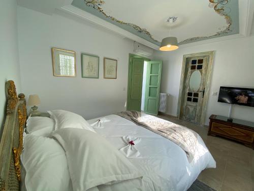 a bedroom with a white bed with white sheets at Dar El Kif - La Marsa in La Marsa