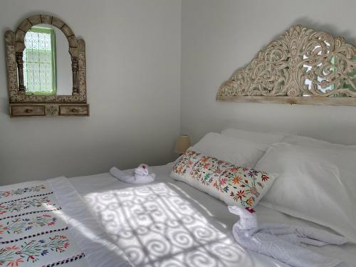 a bedroom with a white bed with a mirror at Dar El Kif - La Marsa in La Marsa