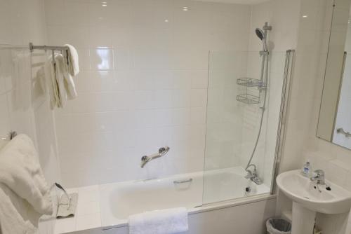 a white bathroom with a shower and a sink at Toothbrush Apartments - Ipswich Waterfront South - Avalon Court in Ipswich
