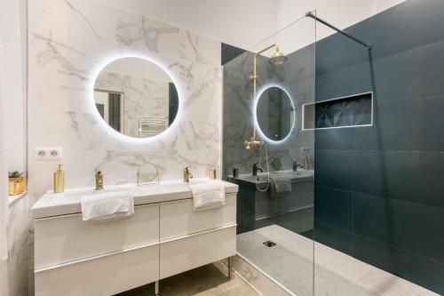 une salle de bain avec un lavabo et un miroir dans l'établissement Petit Saint Jean, à Montpellier