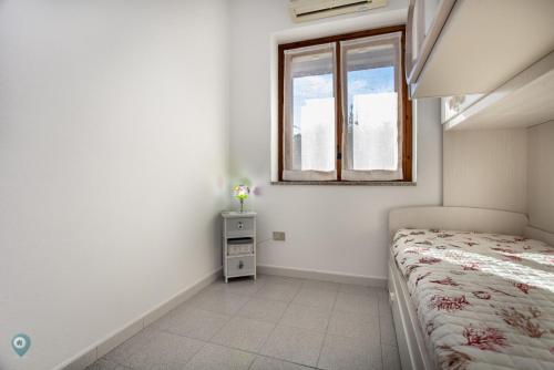 a small bedroom with a bed and a window at Villino Gramsci in San Teodoro