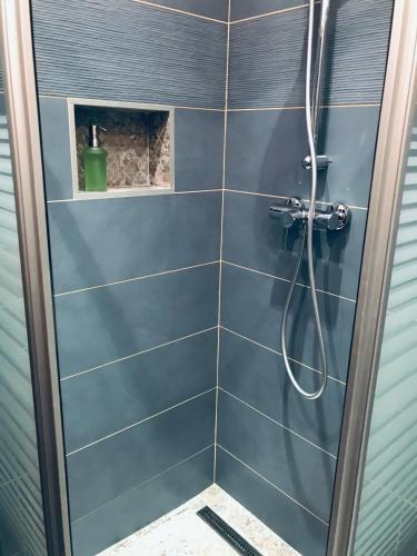 a bathroom with a shower with a blue tiled wall at The Barts City Center - Self Check-in in Vienna