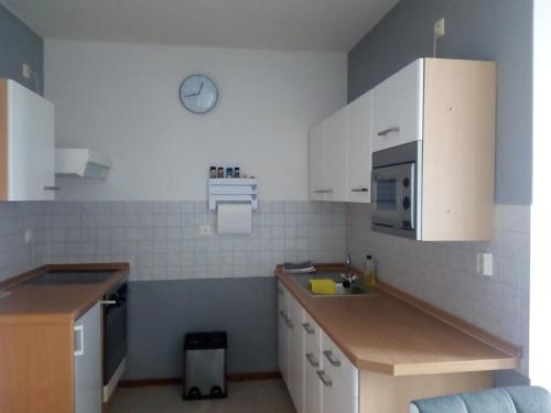 uma cozinha com armários brancos e um lavatório em Ferienwohnung Fröhlich em Bad Suderode