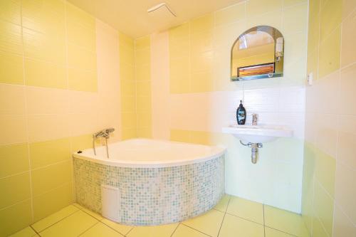 a bathroom with a tub and a sink at Rodinný penzión Rogalo in Mengusovce
