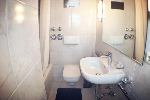 a white bathroom with a sink and a toilet at Workers Apartment- three room apartment with kitchen and wifi in Büsingen