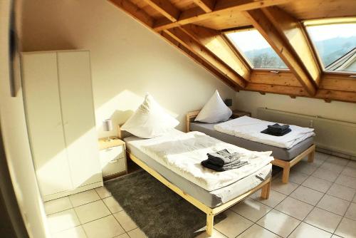 Habitación con 2 camas y 2 ventanas. en Workers Apartment- three room apartment with kitchen and wifi, en Büsingen