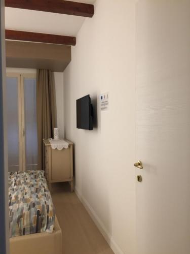 a bedroom with a bed and a tv on the wall at Apulia 35 B&B in Bari