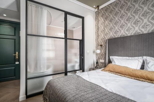 a bedroom with a large bed and a glass door at Zamarin Hotel & Spa in Zikhron Ya‘aqov