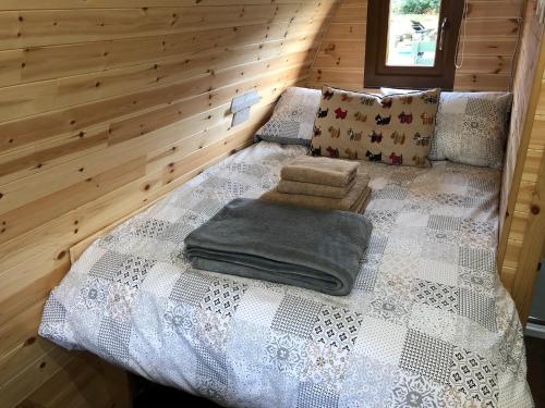 a bed in a room with a wooden wall at Breakish Bay Pods in Breakish