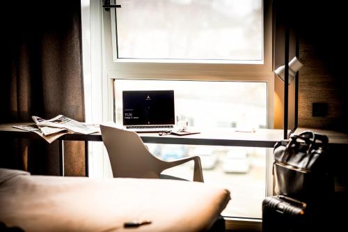 a desk with a computer and a chair in front of a window at ibis Wels in Wels