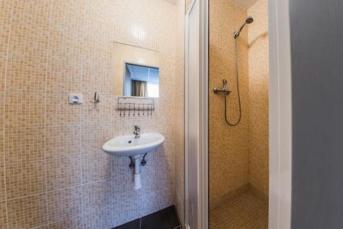 uma casa de banho com um lavatório e um chuveiro em City Hotel B&B em Banská Bystrica