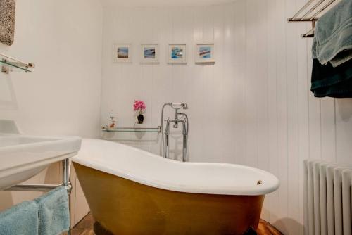 a bath tub in a bathroom next to a sink at Carnegie Library: Austen Apartment 2 bedroom in Mexborough