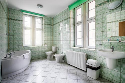 a bathroom with two toilets and a tub and a sink at Jan Kazimierz in Duszniki Zdrój