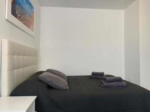 a bedroom with a bed with two pillows on it at Rambla 43 in Alicante