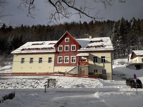 a large house with snow on the roof at Apartmány pod Mariánskými schody in Albrechtice v Jizerských horách