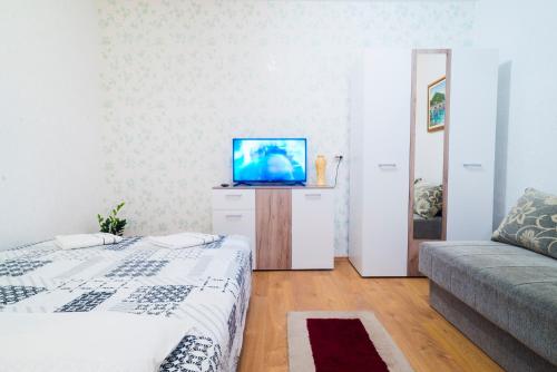 a living room with two beds and a flat screen tv at Apartmani Slavica in Jagodina