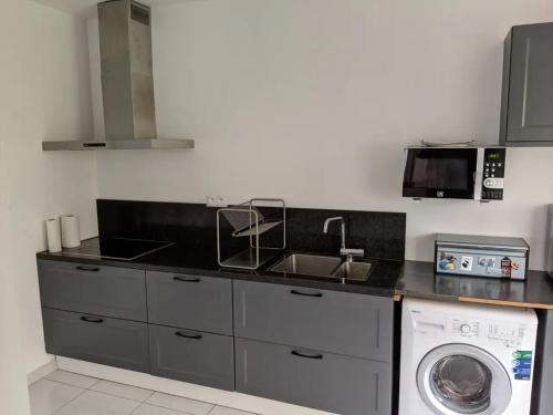 a kitchen with a sink and a washing machine at Rustic room 15 mins from Brussels in Halle
