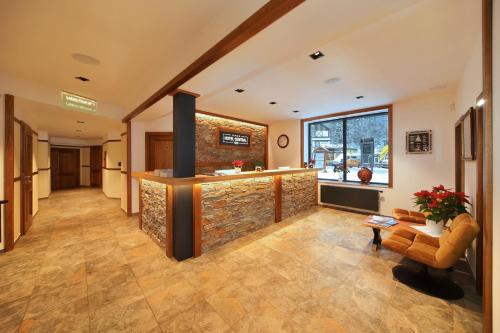 a lobby with a stone wall and a bar at Hotel Central 1920 in Špindlerův Mlýn