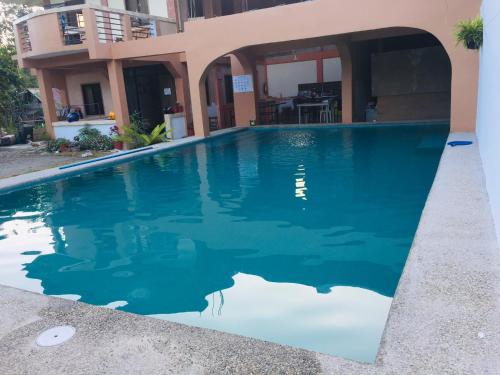 a swimming pool in front of a building at Larosa Hostel Bed and Breakfast in Puerto Princesa City