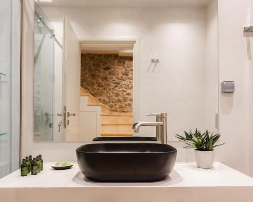 La salle de bains est pourvue d'un lavabo noir sur un comptoir. dans l'établissement Aldia Suites Arachova, à Arachova