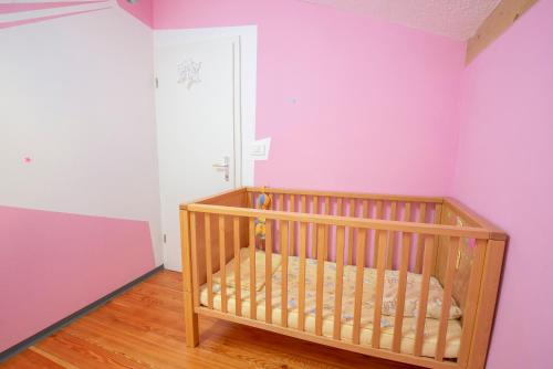 a crib in a room with pink and purple walls at Holiday Home Casa Salina in Sečovlje