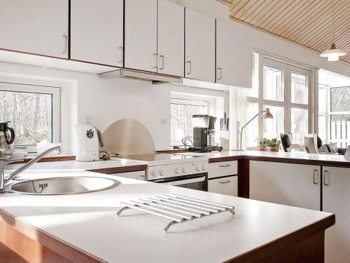 a kitchen with white cabinets and a kitchen counter top at Modern Cedar Cottage near Beach - By Traum Ferienwohnungen in Hasle
