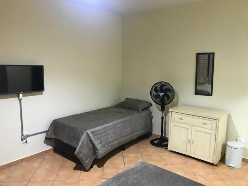 a bedroom with a bed and a fan and a tv at GA2-Hospedagem Próximo ao Aeroporto de Guarulhos in Guarulhos