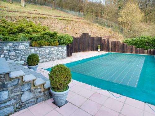 una piscina en un patio trasero con una pared de piedra en Modern Holiday Home in Sosoye with Private Swimming Pool en Sosoye