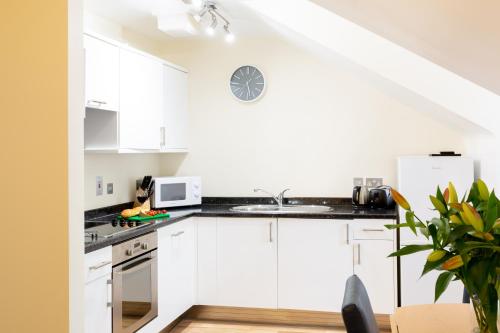 a kitchen with a white counter top and white cabinets at SACO Jersey - Merlin House in Saint Helier Jersey