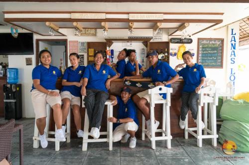 a group of people in blue shirts posing for a picture at Lanas Beach Resort in San Jose