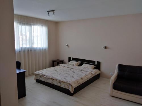 a bedroom with a bed and a chair in it at Sveti Nikola Villas near Borovets in Shiroki Dol