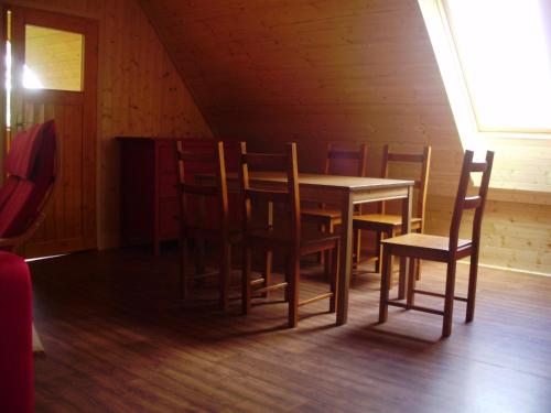 a wooden dining room with a table and chairs at Penzion Diana in Kunžak