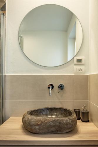 a bathroom with a stone sink in front of a mirror at Appartamenti Villa Gloria in Peschiera del Garda