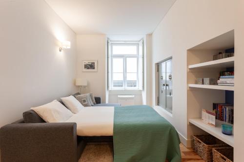sypialnia z łóżkiem i kanapą w obiekcie FLH Downtown Aqua Apartment w Lizbonie
