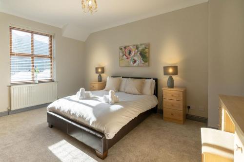 a bedroom with a large bed and a window at Graiglwyd Springs Holiday Cottages in Conwy