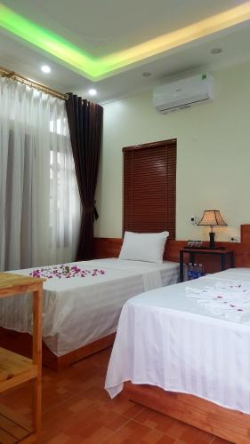 ein Schlafzimmer mit 2 Betten mit Blumen drauf in der Unterkunft Quang Quang Garden Bonsai Homestay in Ninh Bình