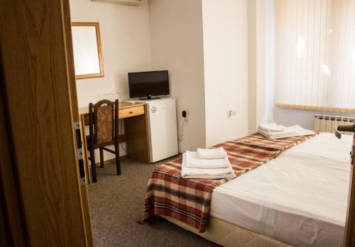 a hotel room with two beds and a television at Family Hotel Saint Iliya in Burgas City