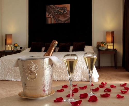 a room with two glasses of champagne and roses at La Côte Saint Jacques in Joigny