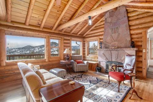 a living room with a fireplace in a log cabin at Bishop's Retreat in Estes Park