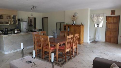 a kitchen and dining room with a table and chairs at Baobab - NUDE - SunEden Family Naturist Resort in Pretoria