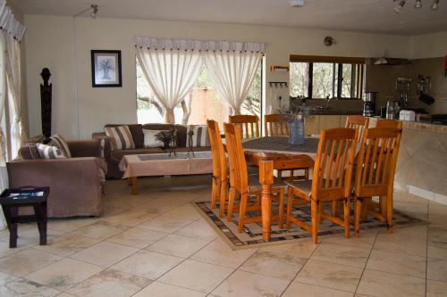 Pretoria的住宿－Baobab - NUDE - SunEden Family Naturist Resort，厨房以及带桌椅的起居室。