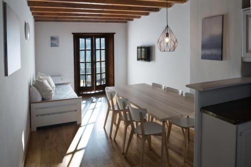 cocina y comedor con mesa de madera y sillas en SNÖ Vall de Boí, en Pla de l'Ermita