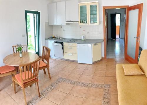 a kitchen and dining room with a table and chairs at Todor Seaside Apartments in Lovrečica