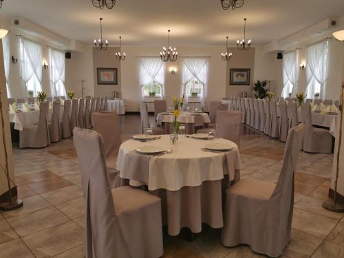 a banquet room with tables and chairs and chandeliers at Hotel Kakadu in Konin