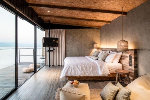 a bedroom with a bed and a view of the ocean at Z9 Resort in Tha Kradan
