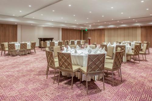 a conference room with tables and chairs and a piano at Crowne Plaza Airport by IHG in Tocumen