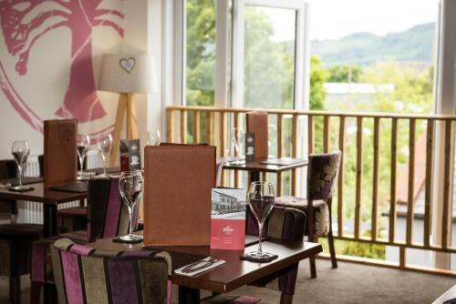 a restaurant with tables and chairs and a balcony at The Birchtree Hotel in Dalbeattie