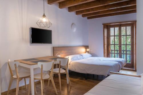 a bedroom with two beds and a table and chairs at SNÖ Vall de Boí in Pla de l'Ermita