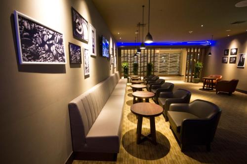 a waiting room with a row of tables and chairs at Crowne Plaza Managua by IHG in Managua